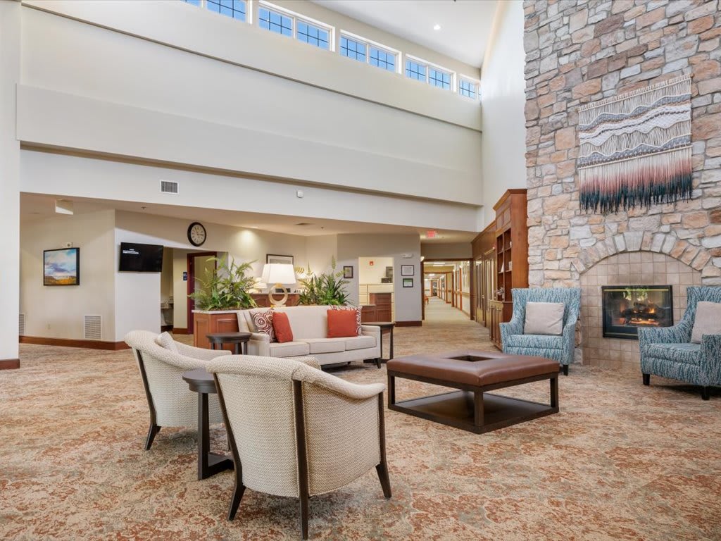 A spacious, modern lobby featuring a seating area with comfortable chairs and a fireplace.