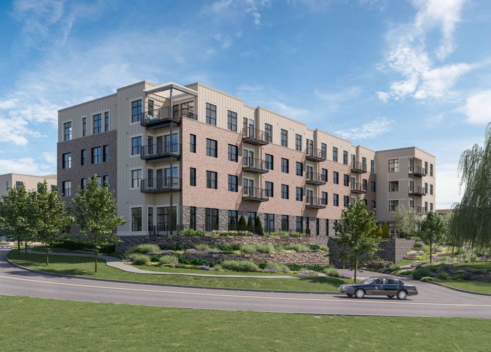 A modern apartment complex with balconies, surrounded by well-maintained landscaping.