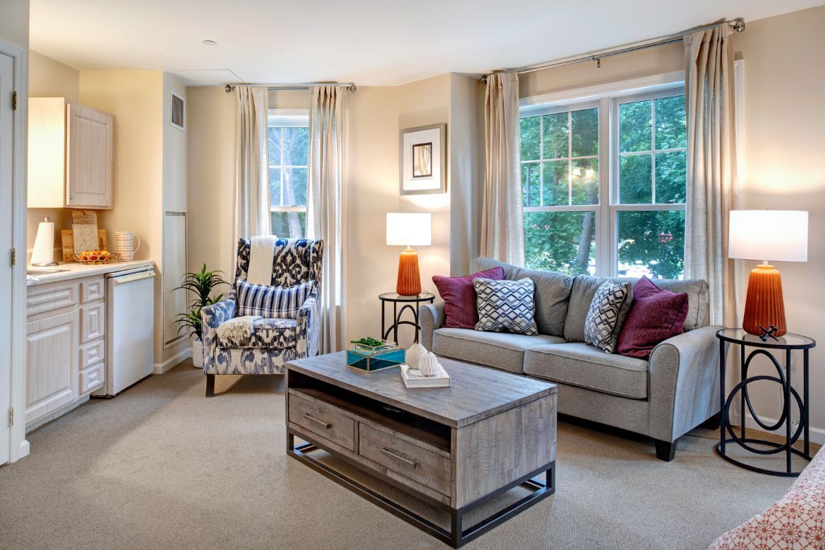 A cozy living room with stylish decor, featuring a comfortable sofa, patterned armchair, and a modern coffee table.