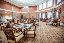 A spacious dining room with elegantly set tables and comfortable seating.