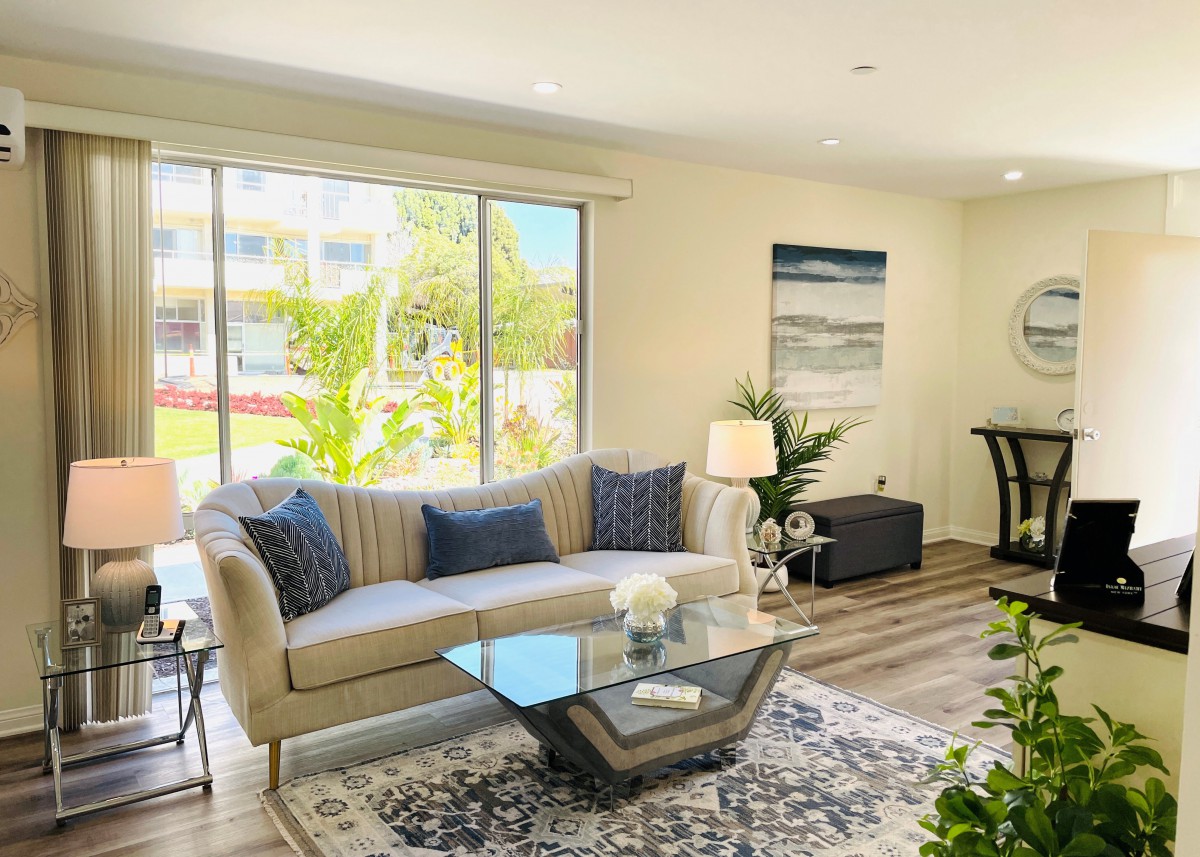 A bright and modern living room with a glass coffee table, comfortable sofa, and stylish decor.