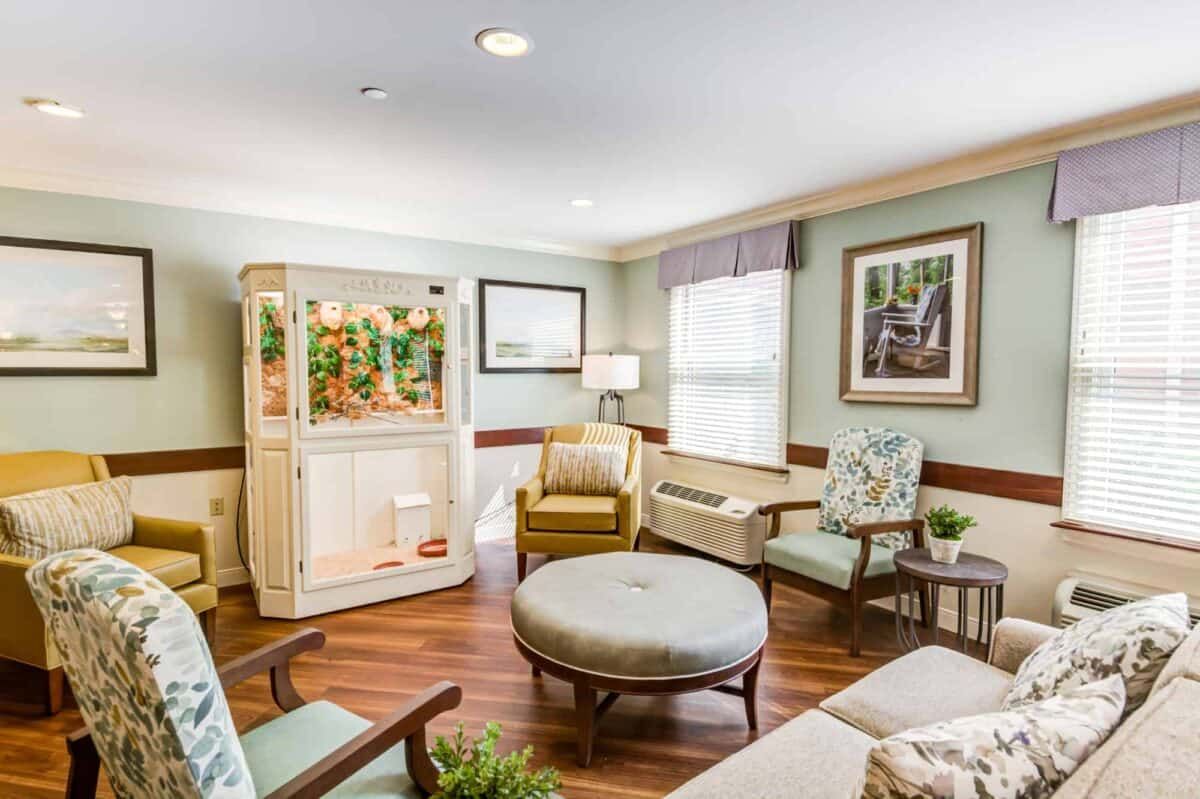 A cozy living room with comfortable seating and a large aquarium.