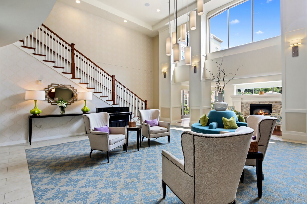 A modern living room with elegant furniture and a grand chandelier.