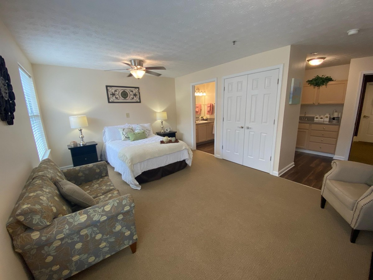 A cozy bedroom with a bed, sofa, and elegant decor.