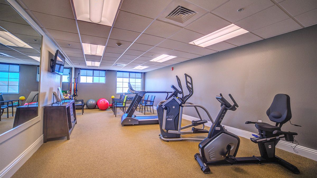 A well-equipped gym with exercise machines and fitness balls.