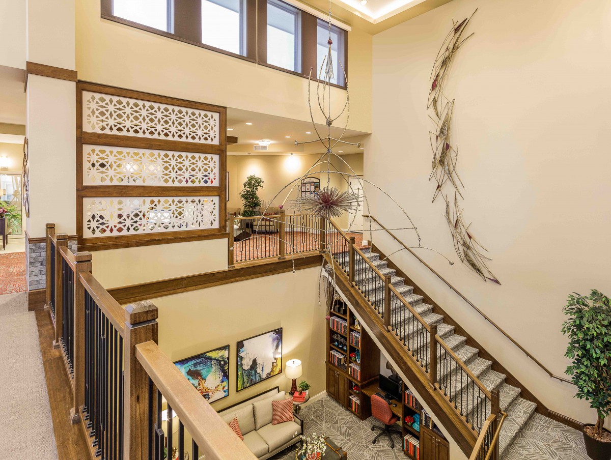 A modern loft-style interior featuring a spacious staircase and contemporary artwork.
