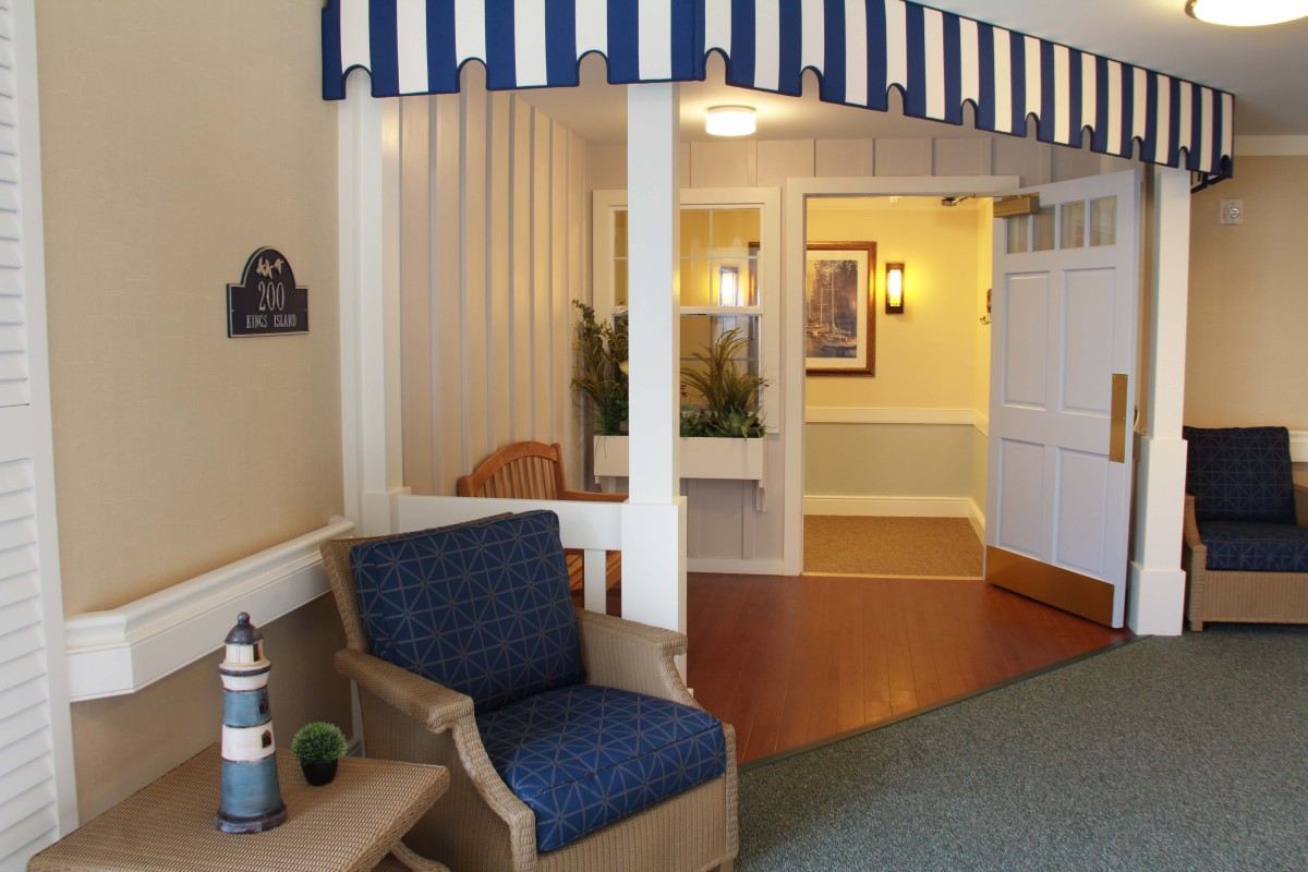 A cozy seating area in a lobby with a blue-striped awning and comfortable chairs.