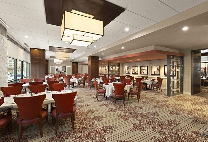 Elegant restaurant interior with finely set tables and warm lighting.