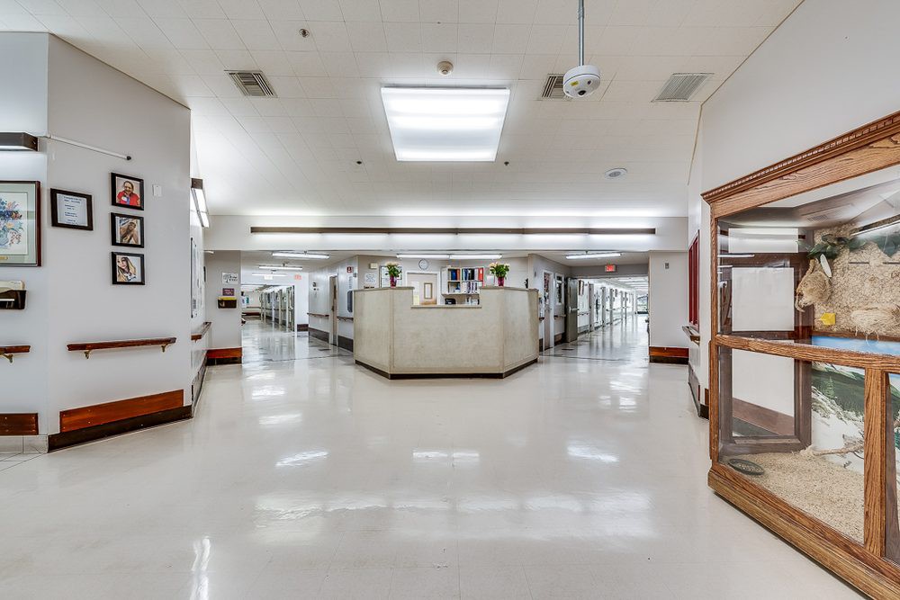 A spacious office interior featuring rows of cubicles under bright fluorescent lights.