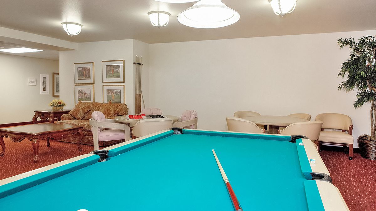 A cozy billiard room featuring a pool table and comfortable seating.