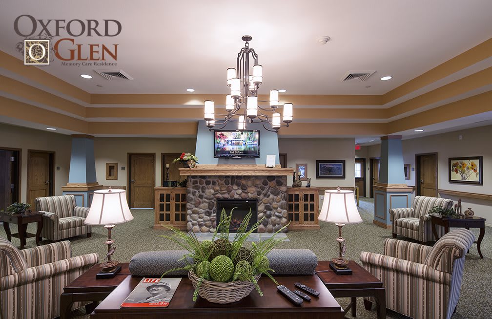 A well-decorated lobby with a central chandelier, stone fireplace, and comfortable seating.