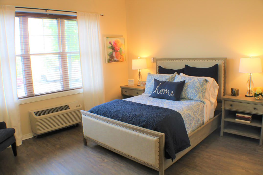 A cozy bedroom with a neatly made bed and soft lighting.