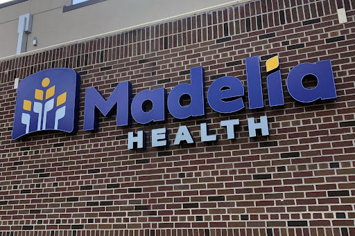 Signage for Madelia Health displayed prominently on a brick wall.