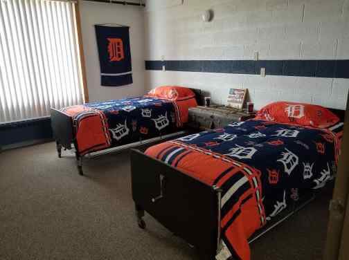 A sports-themed bedroom with two beds decorated with matching logo blankets.