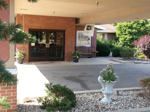 The welcoming entrance of a building, adorned with potted plants and a well-kept outdoor space.