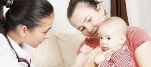 Two women attentively looking at a baby, symbolizing family and togetherness.