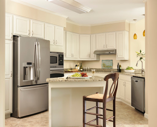 A modern kitchen featuring light-colored cabinetry, stainless steel appliances, and a cozy island setup.