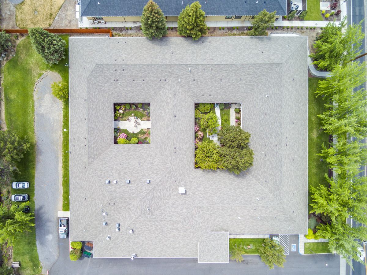 Aerial view of a residential building with open courtyards and surrounding greenery.