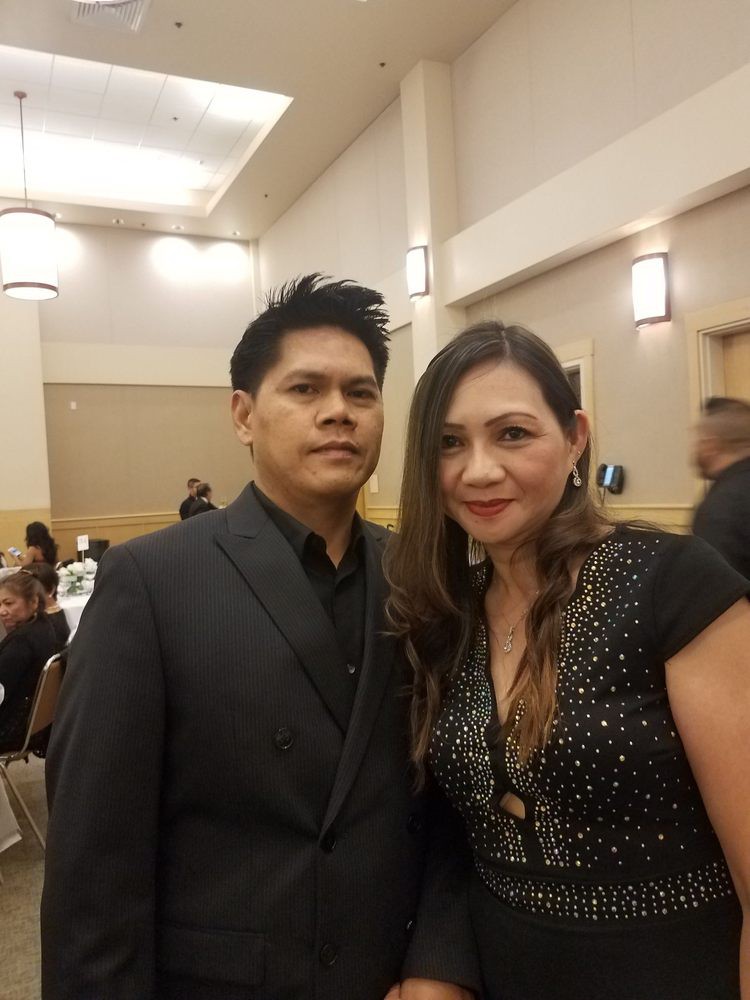 A couple dressed in formal attire at an indoor event.