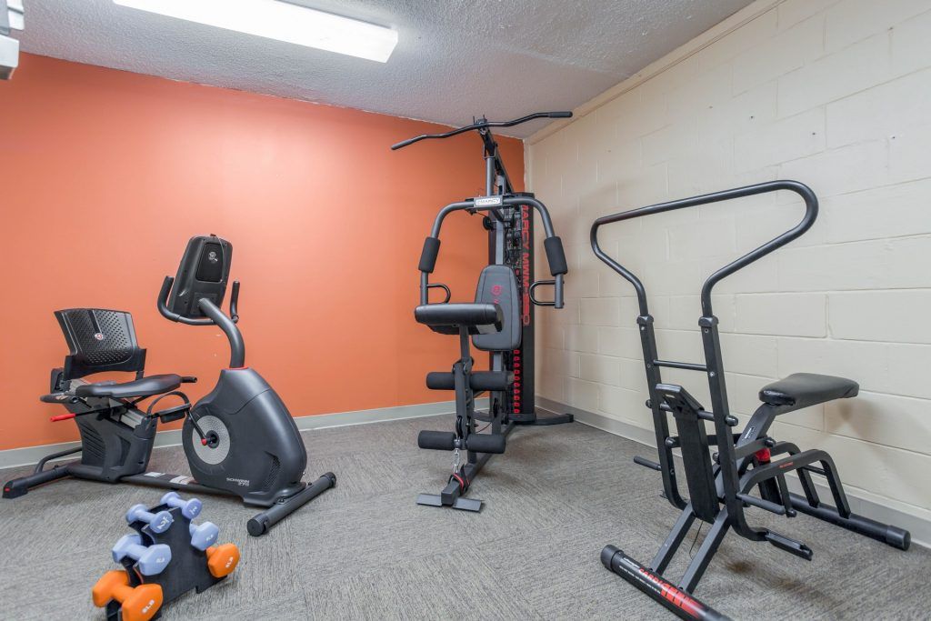 A home gym setup with various exercise machines and equipment.