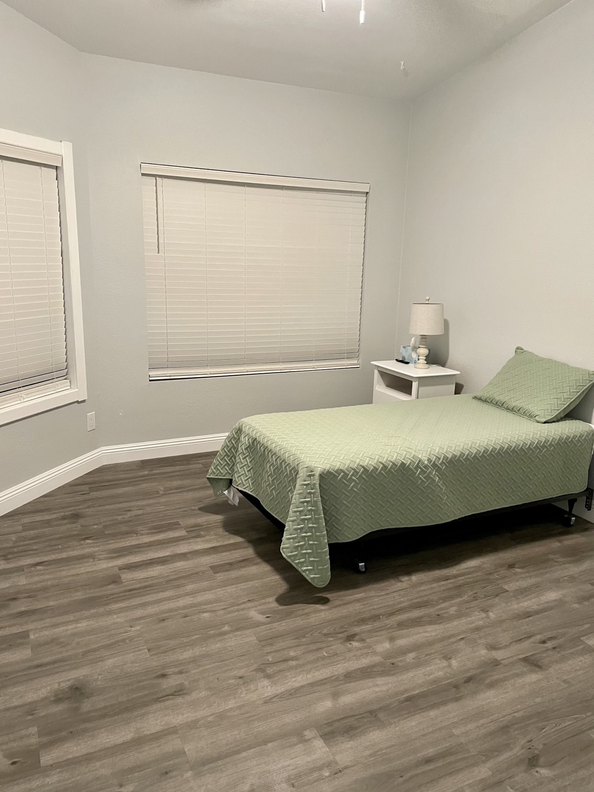 A minimalist bedroom with a single bed and nightstand.