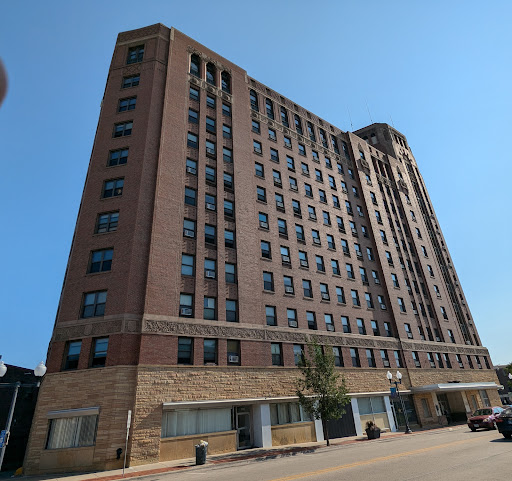 A tall brick building showcasing classic architecture against a clear blue sky.