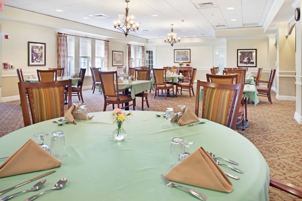 An elegant dining room with neatly arranged tables and warm lighting.
