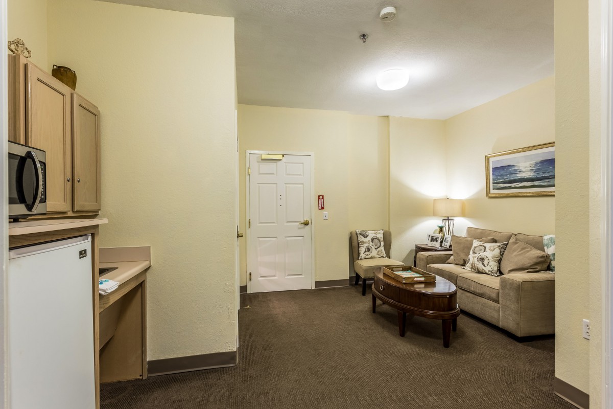 A cozy living room with a sofa, coffee table, lamp, and decorative elements.