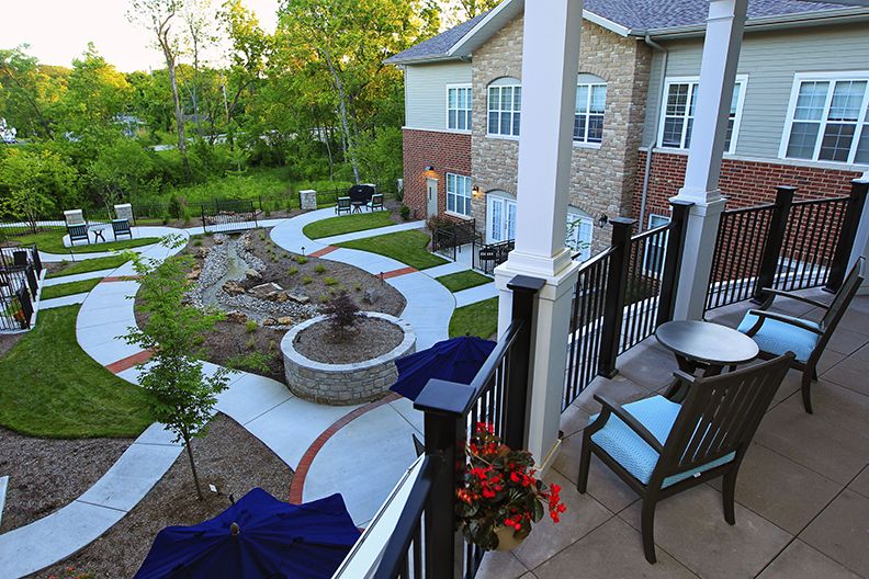 A well-landscaped backyard with a patio, outdoor seating, and a fire pit.
