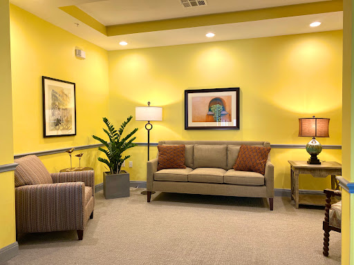 A cozy waiting room featuring yellow walls, comfortable seating, and decorative elements.