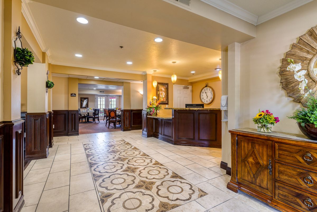 A warmly lit hotel lobby with a reception desk and elegant decor.