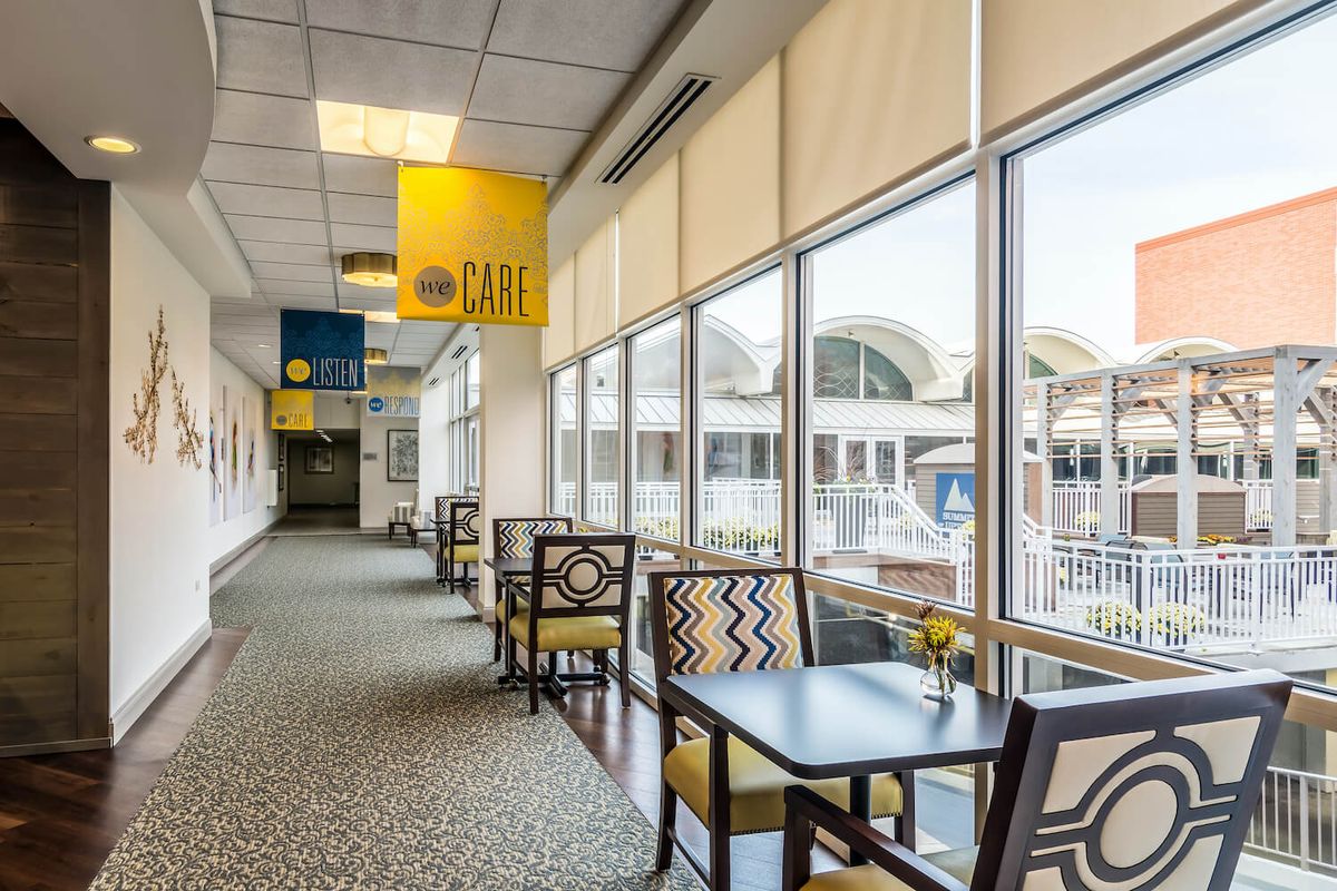 A modern airport lounge with seating arrangements, featuring large windows and natural lighting.