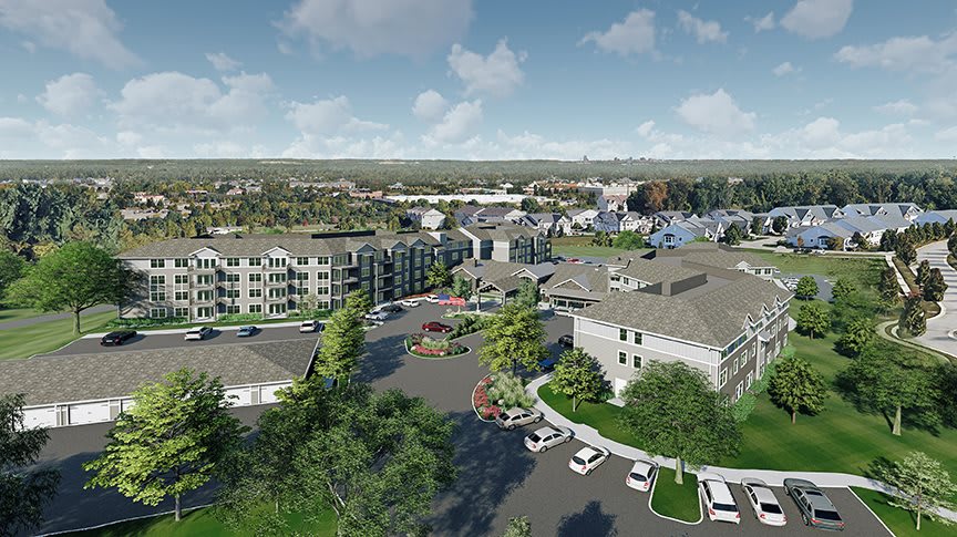 Aerial view of residential complex with surrounding greenery and parking lot.