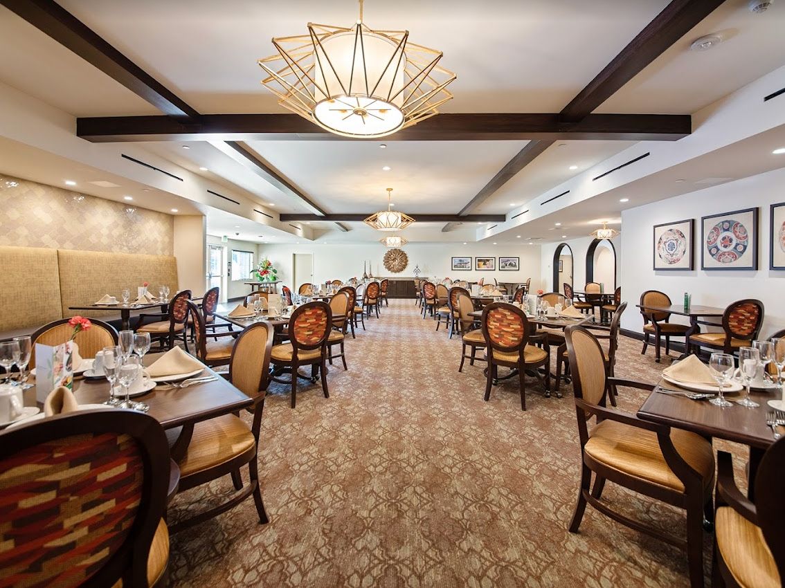 A spacious and elegantly decorated dining room with neatly arranged tables and chairs.