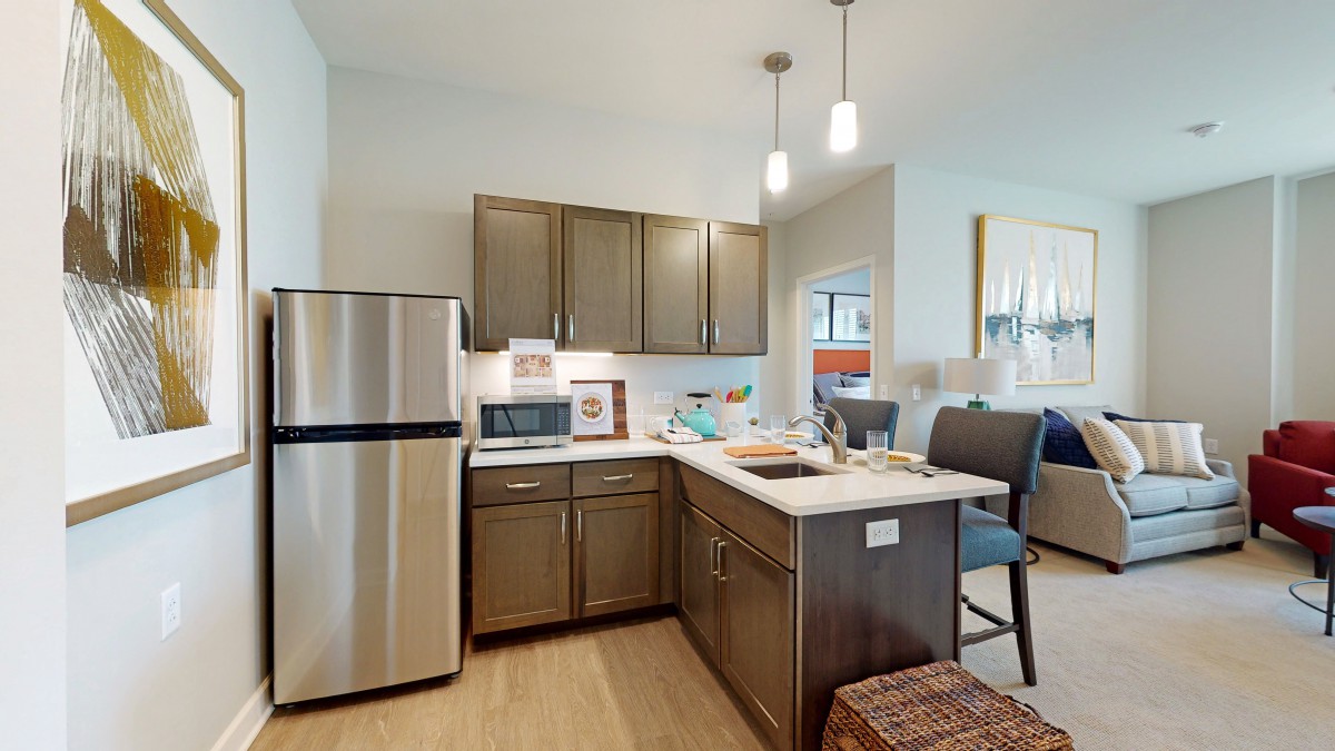 A modern kitchen featuring stainless steel appliances, sleek cabinets, and a central island with bar stools.