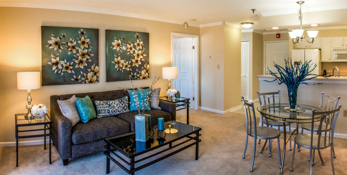 A cozy living room featuring a comfortable sofa, decorative pillows, and elegant artwork on the wall.