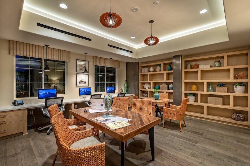 A modern office space featuring computers, bookshelves, and comfortable seating for meetings.