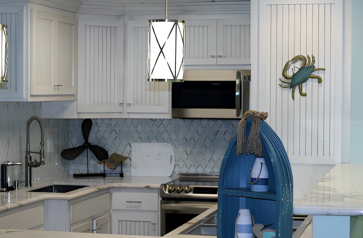 A modern kitchen with white cabinetry and nautical-themed decor, featuring a pendant light and blue decorative elements.