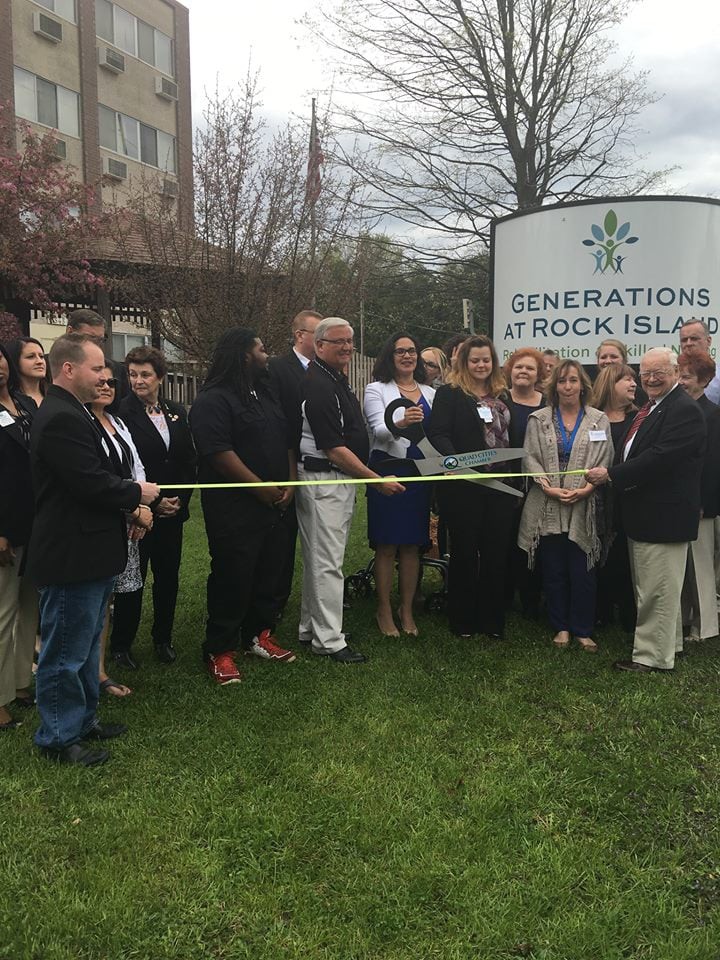 A group of people attending a ribbon-cutting ceremony at Generations at Rock Island.