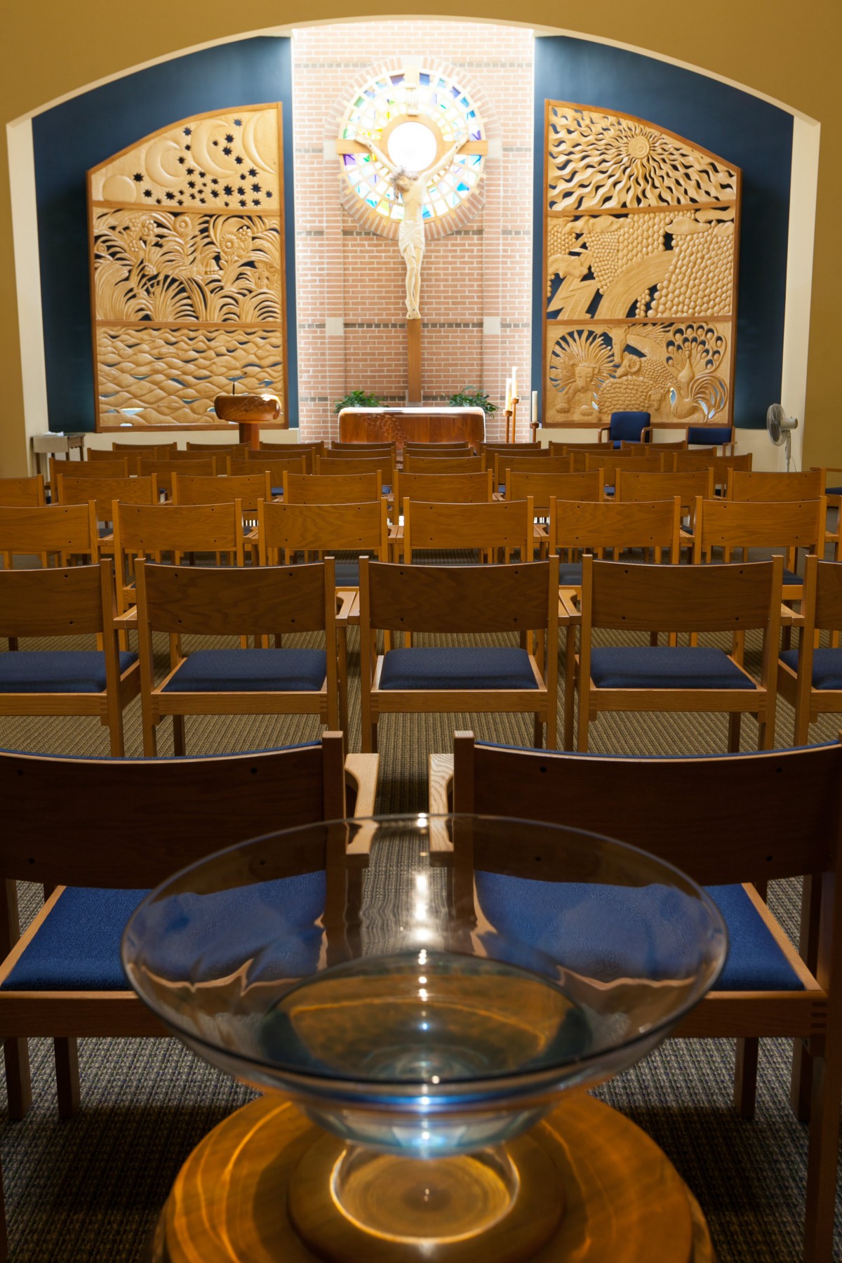 Interior view of a chapel with rows of chairs facing the altar.