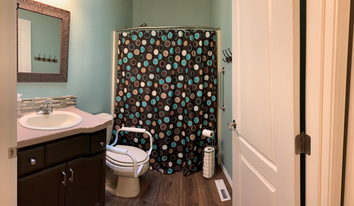 A cozy bathroom with a colorful polka dot shower curtain.