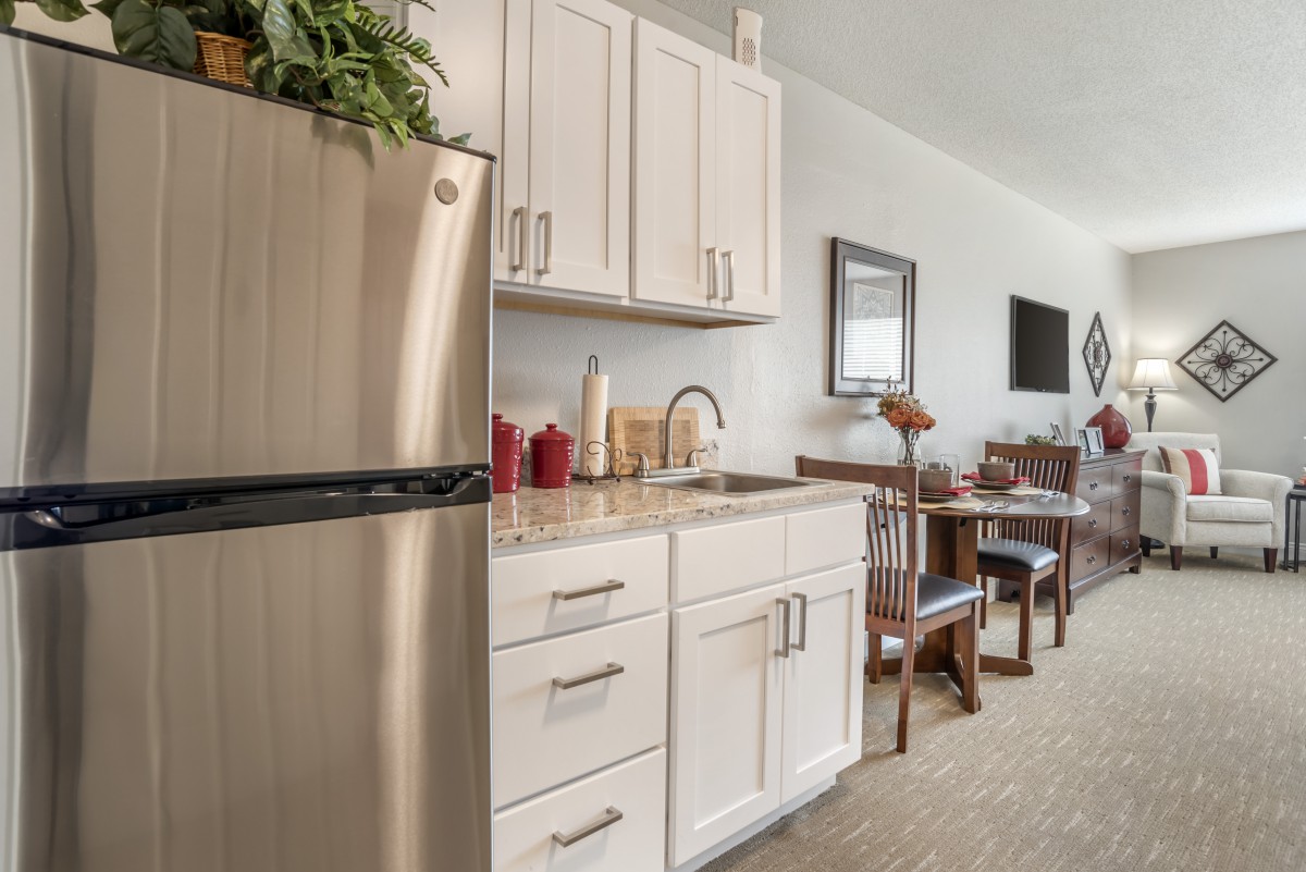 A modern kitchen with stainless steel appliances and a dining area.