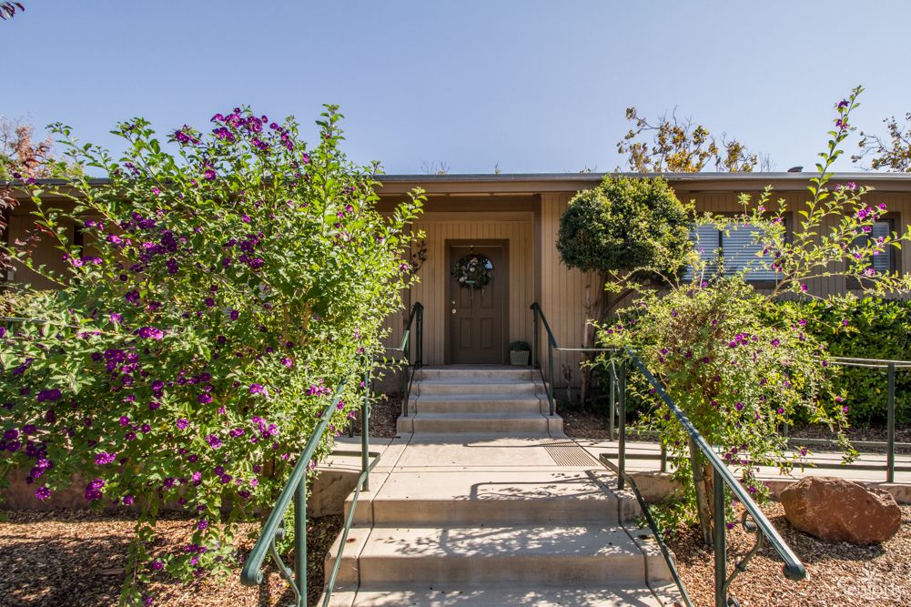 A house entrance with a pathway and lush garden.