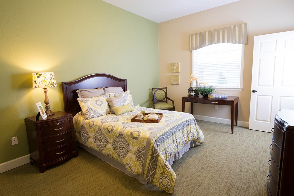 A cozy bedroom with a neatly made bed, elegant furniture, and soft lighting.
