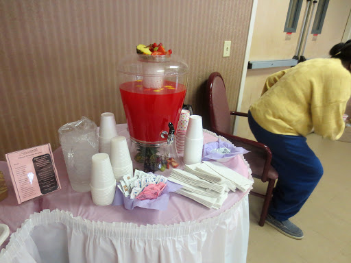 A table set up with a beverage dispenser filled with red punch, accompanied by cups and party supplies, perfect for an event.