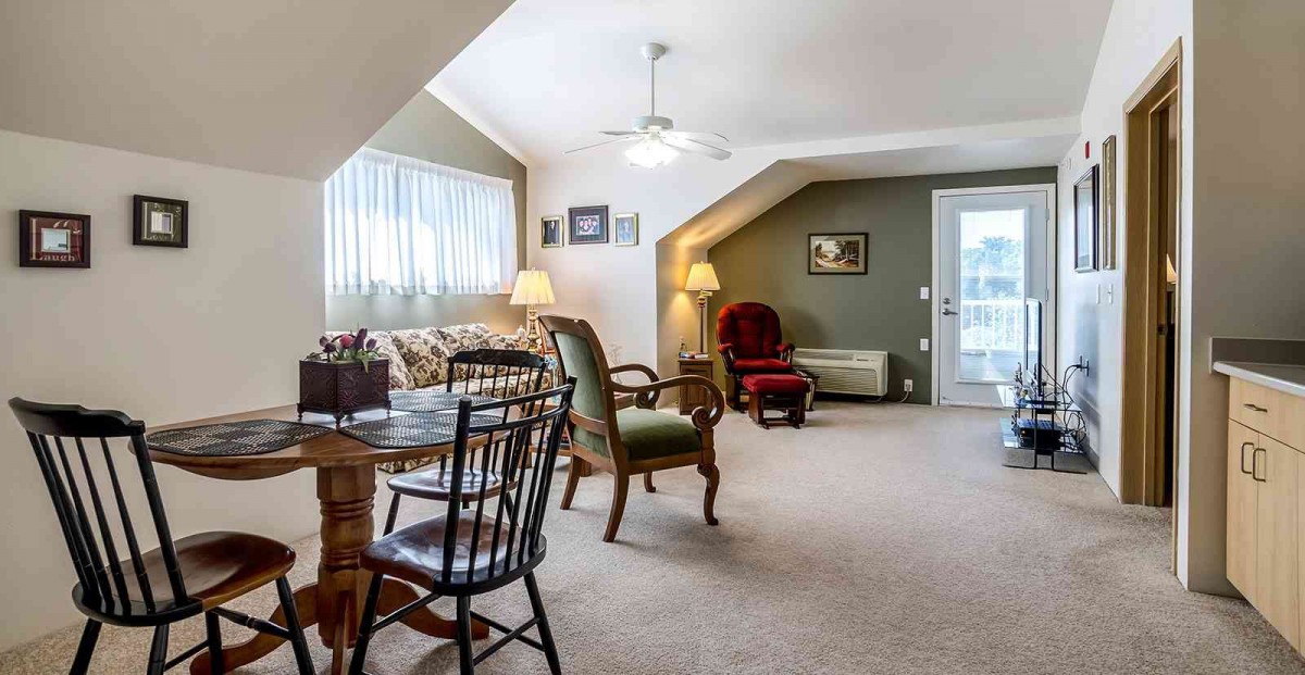 A cozy living room with various seating options and warm lighting.