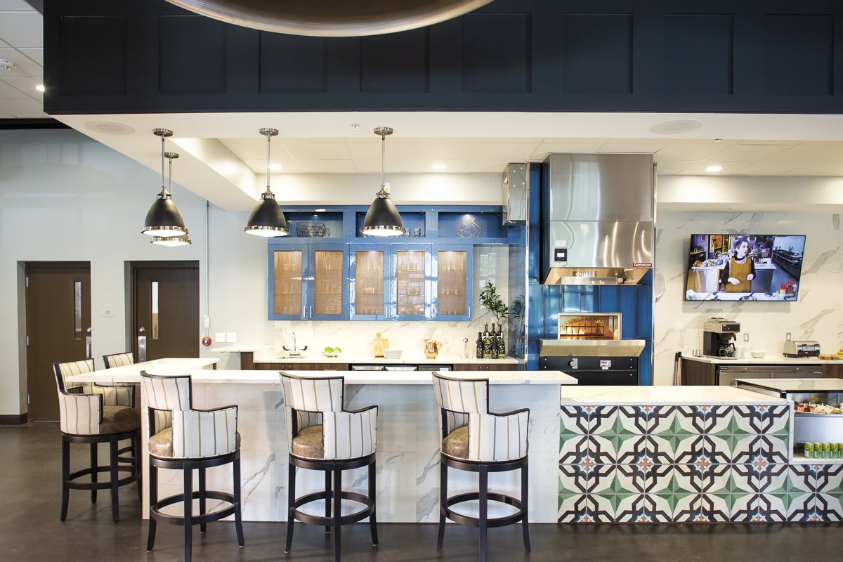 A modern kitchen with bar seating and stylish pendant lights.
