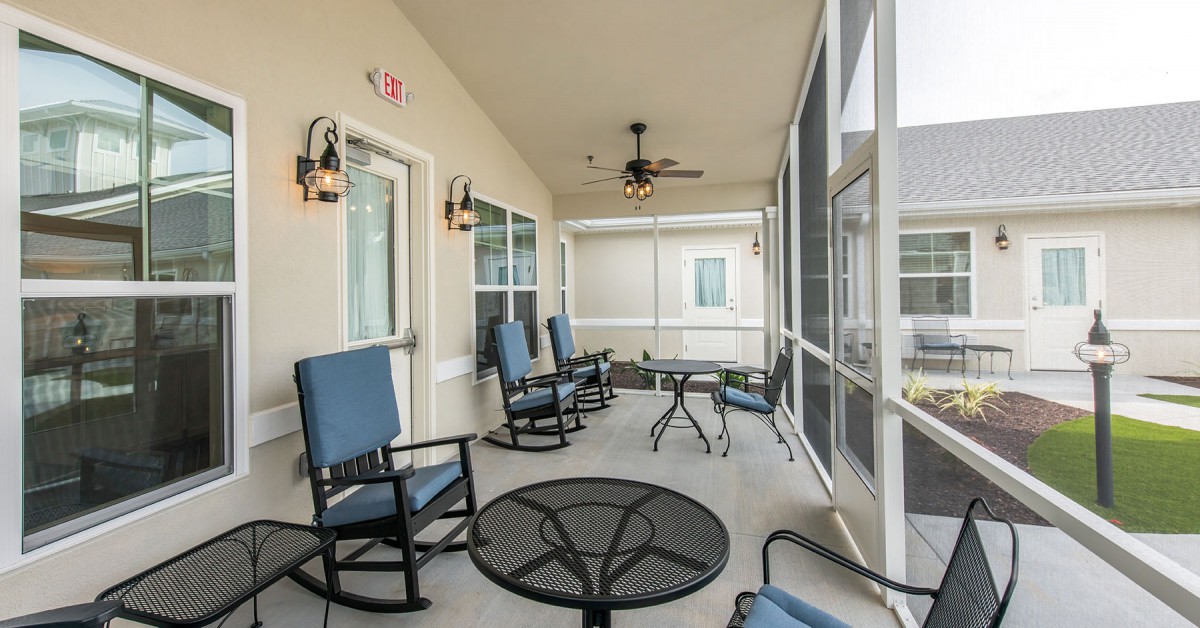A spacious screened-in patio with comfortable seating and ceiling fans.