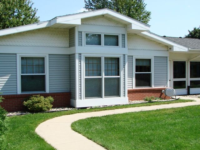A single-story house with a well-maintained lawn and pathway leading to the entrance.