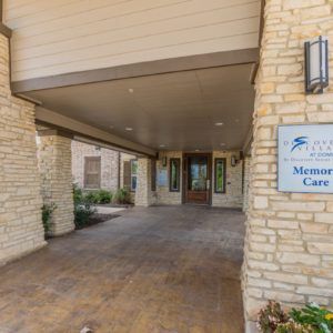 Entrance with stone walls and a covered walkway leading to the building.